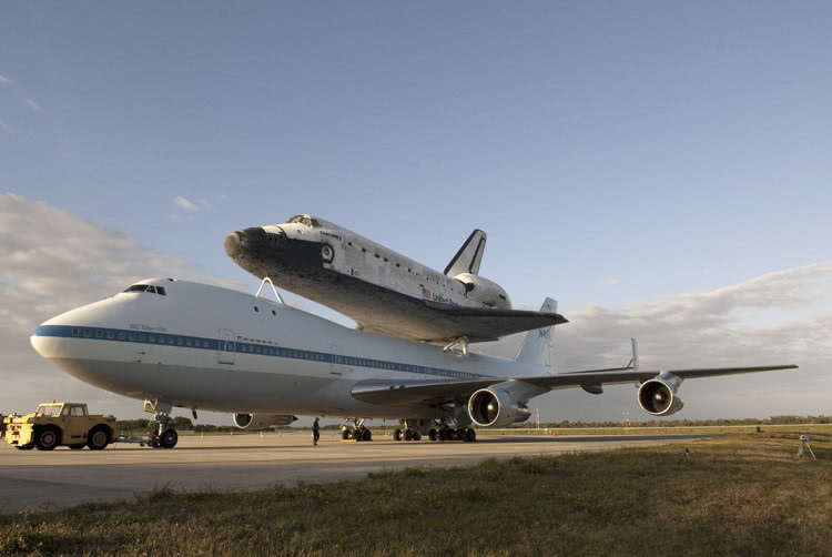 Space shuttle sitting on top of an airplane